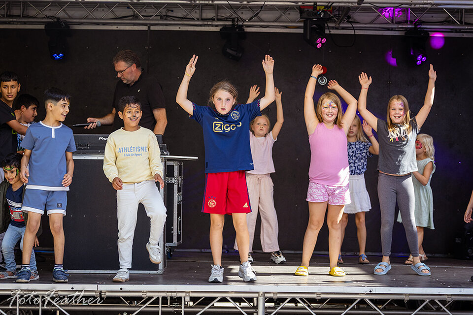 Kinderen geven een dansvoorstelling op een podium in de buitenlucht